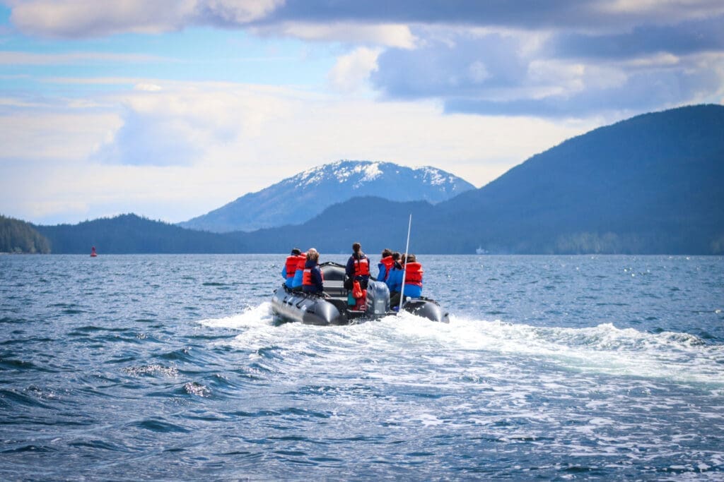 Zodiac boat with passengers viewed from behind as it travels at speed