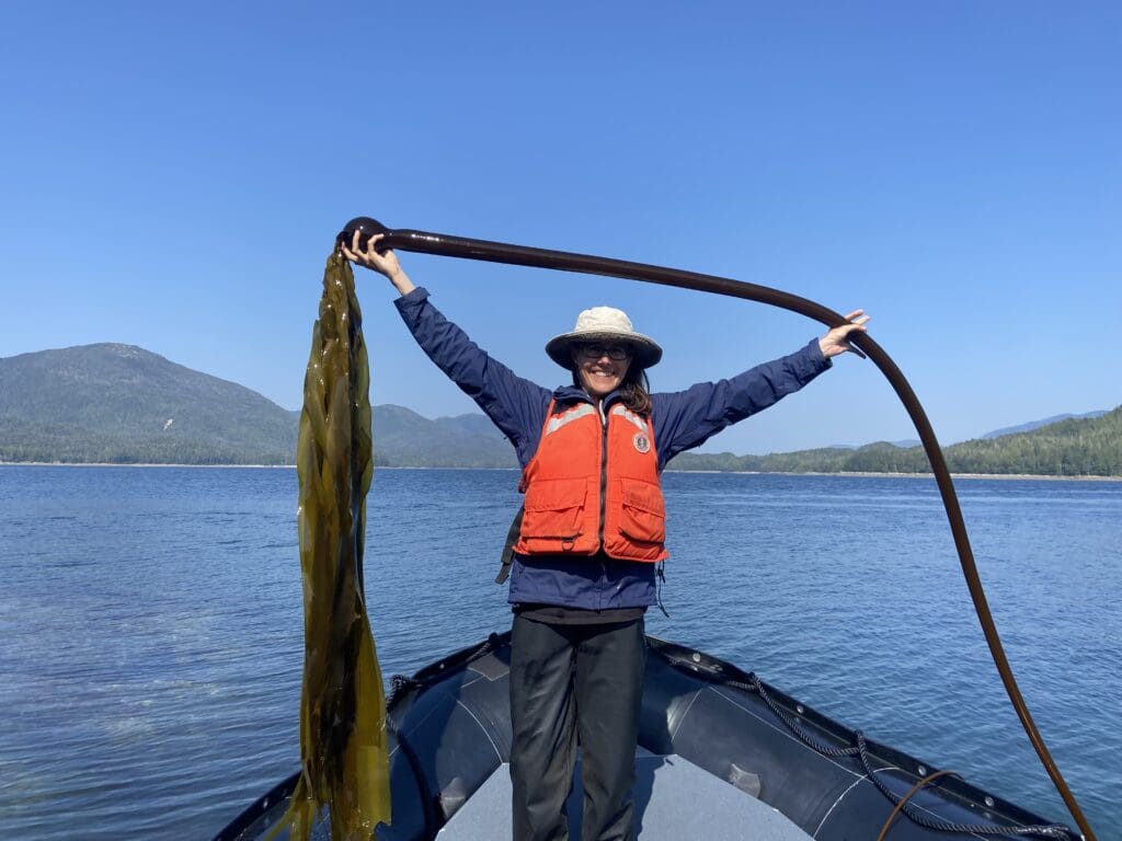 Jenny with Bull Kelp Woman holding Bull Kelp at the bow of a Zodiac
