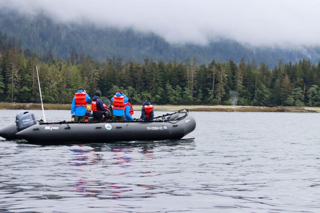 Viewing Wildlife from a Zodiac Passengers dressed in rain gear and life jackets view wildlife from a Zodiac boat